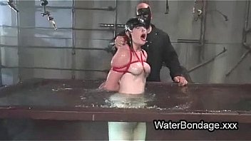 Brunette in rope bondage dive in water